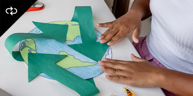 Un bambino che realizza una mappa del mondo in carta con nastro adesivo a marchio Scotch™

