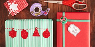 Creare un aspetto tradizionale per l'impacchettamento regalo natalizio con colori rosso, verde e bianco, e attaccare figure di carta con il Nastro biadesivo Scotch®

