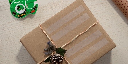 Creare etichette regalo utilizzando il Nastro adesivo Scotch® Magic™ su un regalo impacchettato
